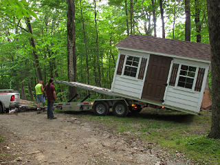 Shed teetering on tail of trailer