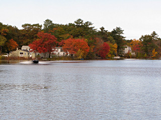 Riotous fall colors over pond with boat